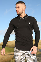 A man wearing a Prestige Camo Hooded Tee – Black with camouflage side panels, paired with matching shorts.