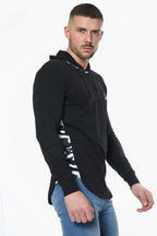 A man wearing a black Prestige Camo Hooded Tee featuring a white camouflage stripe down the sleeves.